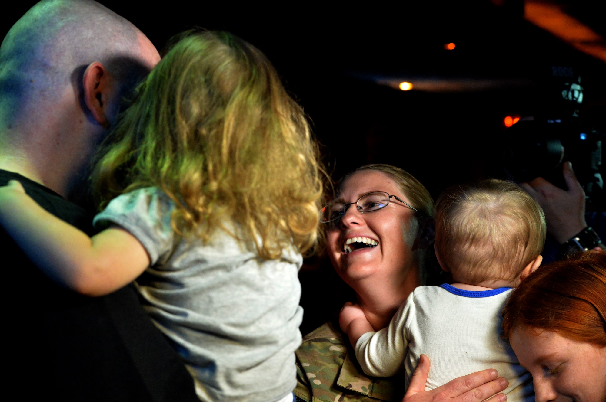 Staff Sgt. Julie Mauldin 432nd Air Craft Maintenance Squadron crew chief, center, greets her family on Feb 13. 2015, at the Shark Reef Aquarium in Las Vegas. Mauldin coordinated the surprise with local organizations after being notified that she would return home from her deployment to Southwest Asia one month earlier than planned. (U.S. Air Force photo by Senior Airman Adarius Petty/Released)