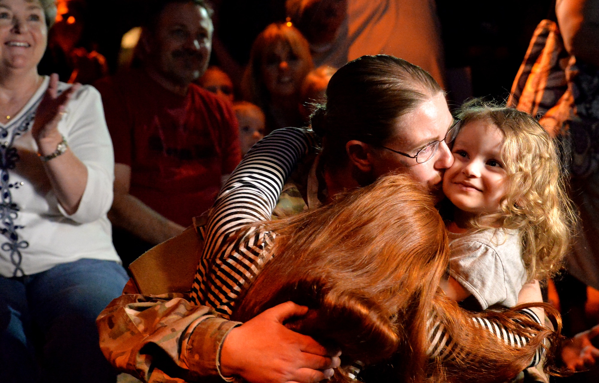 Staff Sgt. Julie Mauldin 432nd Air Craft Maintenance Squadron crew chief, kisses her daughters Caitlynn, 3, right, and Samantha, 11, after surprising on Feb. 13, 2015, at the Shark Reef Aquarium in Las Vegas. Mauldin’s homecoming surprise was greeted with applause from aquarium patrons. (U.S. Air Force photo by Senior Airman Adarius Petty/Released) 
