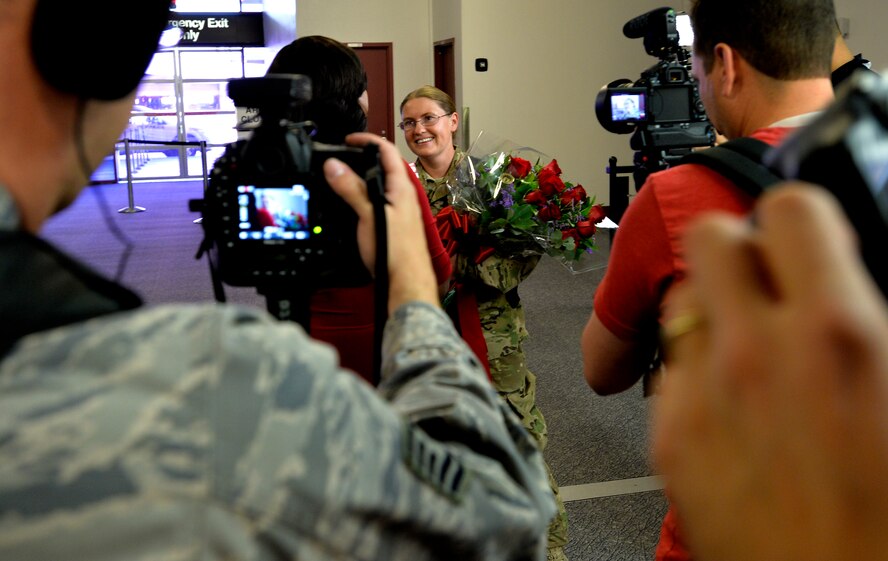 Staff Sgt. Julie Mauldin, a crew chief with the 432nd Aircraft Maintenance Squadron, is interviewed by Monica Jackson, a co-anchor with Fox 5 News Surprise Squad, as she returns home from a deployment  to Southwest Asia, Feb. 11, 2015, at McCarran International Airport in Las Vegas. Mauldin  planned to surprise her family with her early homecoming during the family’s regular visit to the Shark Reef Aquarium. (U.S. Air Force photo by Senior Airman Adarius Petty/Released)
