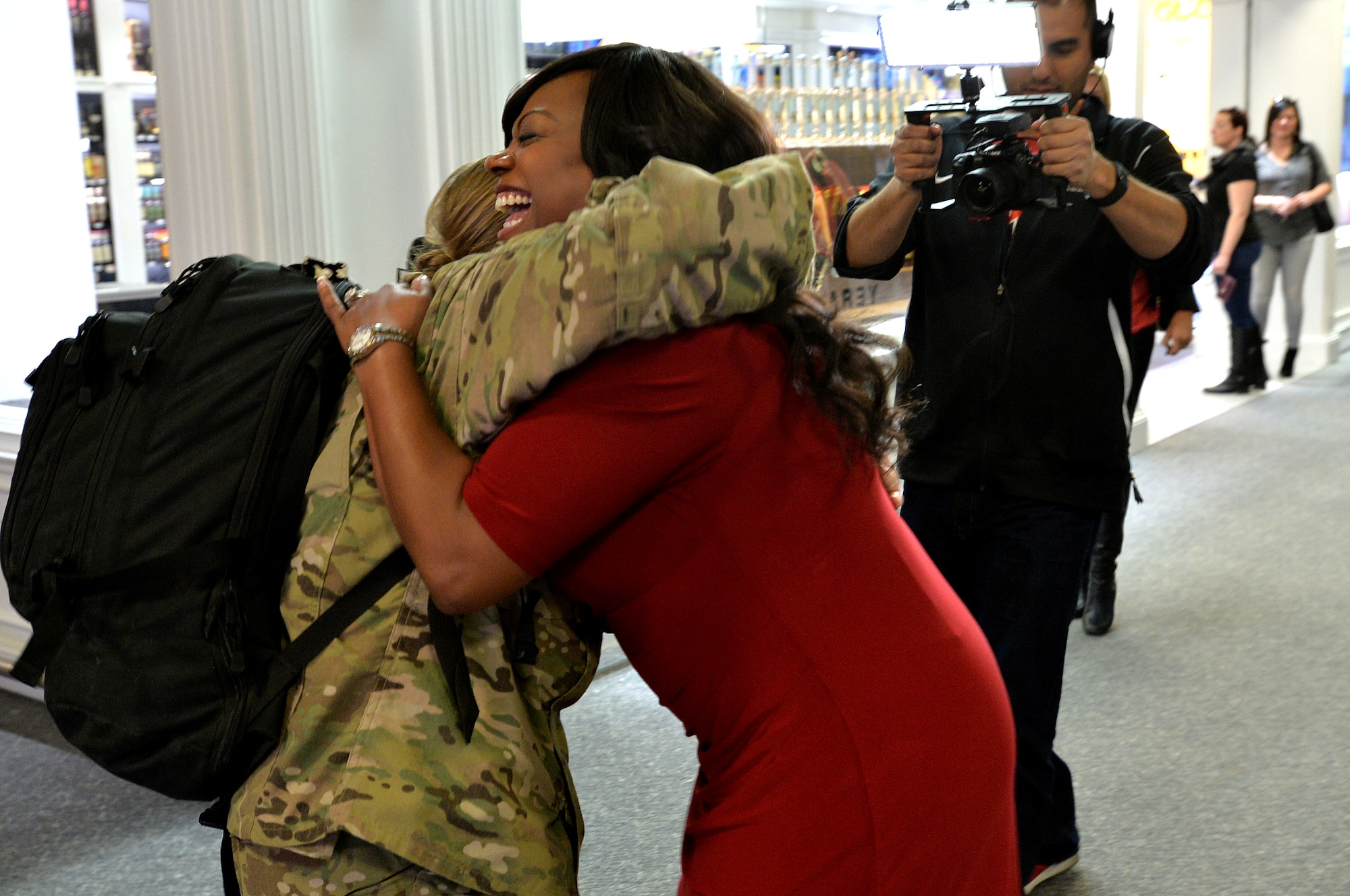 Staff Sgt. Julie Mauldin, a crew chief with the 432nd Aircraft Maintenance Squadron, is greeted by Monica Jackson, a co-anchor with Fox 5 News Surprise Squad, as she returns home from a deployment to Southwest Asia, Feb. 11, 2015, at McCarran International Airport in Las Vegas. Mauldin planned to surprise her family with her early homecoming during the family’s usual visit to the Shark Reef Aquarium. (U.S. Air Force photo by Senior Airman Adarius Petty/Released)