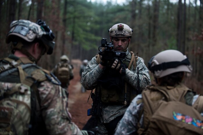 Staff Sgt. Steven Witt, a broadcaster assigned to the 1st Combat Camera Squadron, documents a patrol Feb. 10, 2015, at North Auxiliary Airfield, S.C., during an Ability to Survive and Operate exercise. The ATSO exercise is an annual event designed to test the ability of Air Force combat camera Airmen to survive, operate and provide imagery in an austere environment. Combat camera Airmen document a full range of military operations in support of senior leaders and combatant commanders. (U.S. Air Force photo/Senior Airman Jared Trimarchi)