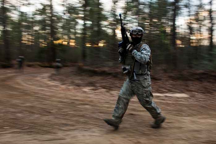 Senior Airman Aaron Richardson, a broadcaster assigned to the 1st Combat Camera Squadron, rounds a corner Feb. 10, 2015, at North Auxiliary Airfield, S.C., during an Ability to Survive and Operate exercise. The ATSO exercise is an annual event designed to test the ability of Air Force combat camera Airmen to survive, operate and provide imagery in an austere environment. Combat camera Airmen document a full range of military operations in support of senior leaders and combatant commanders. (U.S. Air Force photo/Senior Airman Jared Trimarchi)