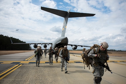 Airmen from the 1st Combat Camera Squadron, 3rd Combat Camera Squadron (from Joint Base San Antonio) and the 628th Civil Engineer Squadron explosive ordnance disposal, deplane a C-17 Globemaster III during the start of an Ability to Survive and Operate Exercise Feb.  9, 2015 at North Auxiliary Airfield, S.C. The ATSO exercise is an annual event designed to test the ability of Air Force combat camera Airmen to survive, operate and provide imagery in an austere environment. Combat camera Airmen document a full range of military operations in support of senior leaders and combatant commanders. (U.S. Air Force photo/Senior Airman Jared Trimarchi)
