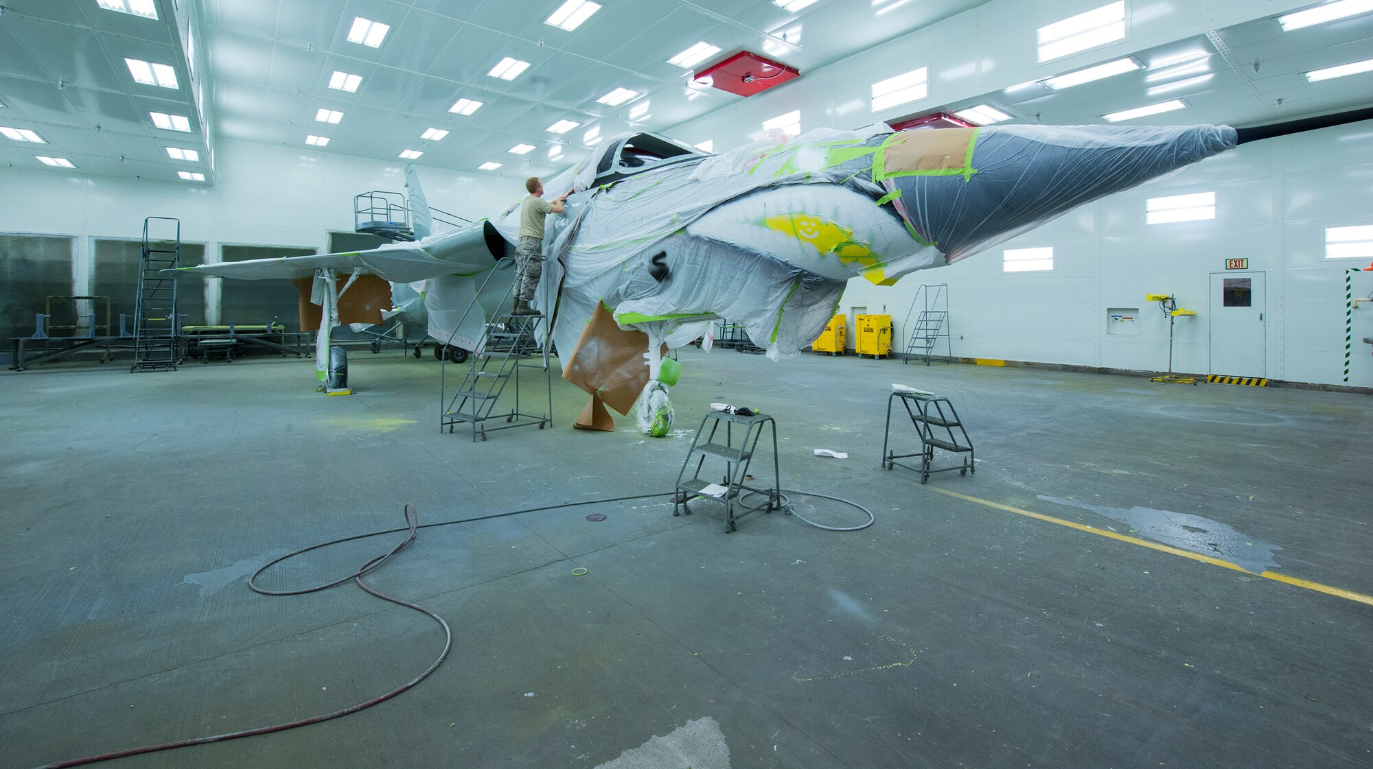 U.S. Air Force Senior Airman Christopher Still, 23d Equipment Maintenance Squadron aircraft structural maintenance journeyman, places tape on F-105 Thunderchief “Thud” before applying the next coat of paint Feb. 11, 2015, at Moody Air Force Base, Ga. Thud was repainted to replicate the aircraft’s look when the Flying Tigers were stationed at McConnell Air Force Base, Kan. (U.S. Air Force photo by Airman 1st Class Ceaira Tinsley/Released)