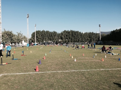 Volunteers await the arrival of the students from the American School of Doha for the school's annual National Sport Day, Feb. 10, 2015.  Members from the 437th Operation Group who are currently deployed to Al Udeid Air Base participated in the school's National Sports Day, which is held every year on the second Tuesday in February, and  emphasizes the benefits of physical activity for a healthy lifestyle among its population. Students rotated through activity stations that included three-legged and potato sack races, relay races, throwing and jumping competitions, indoor rock climbing and even water activities. 