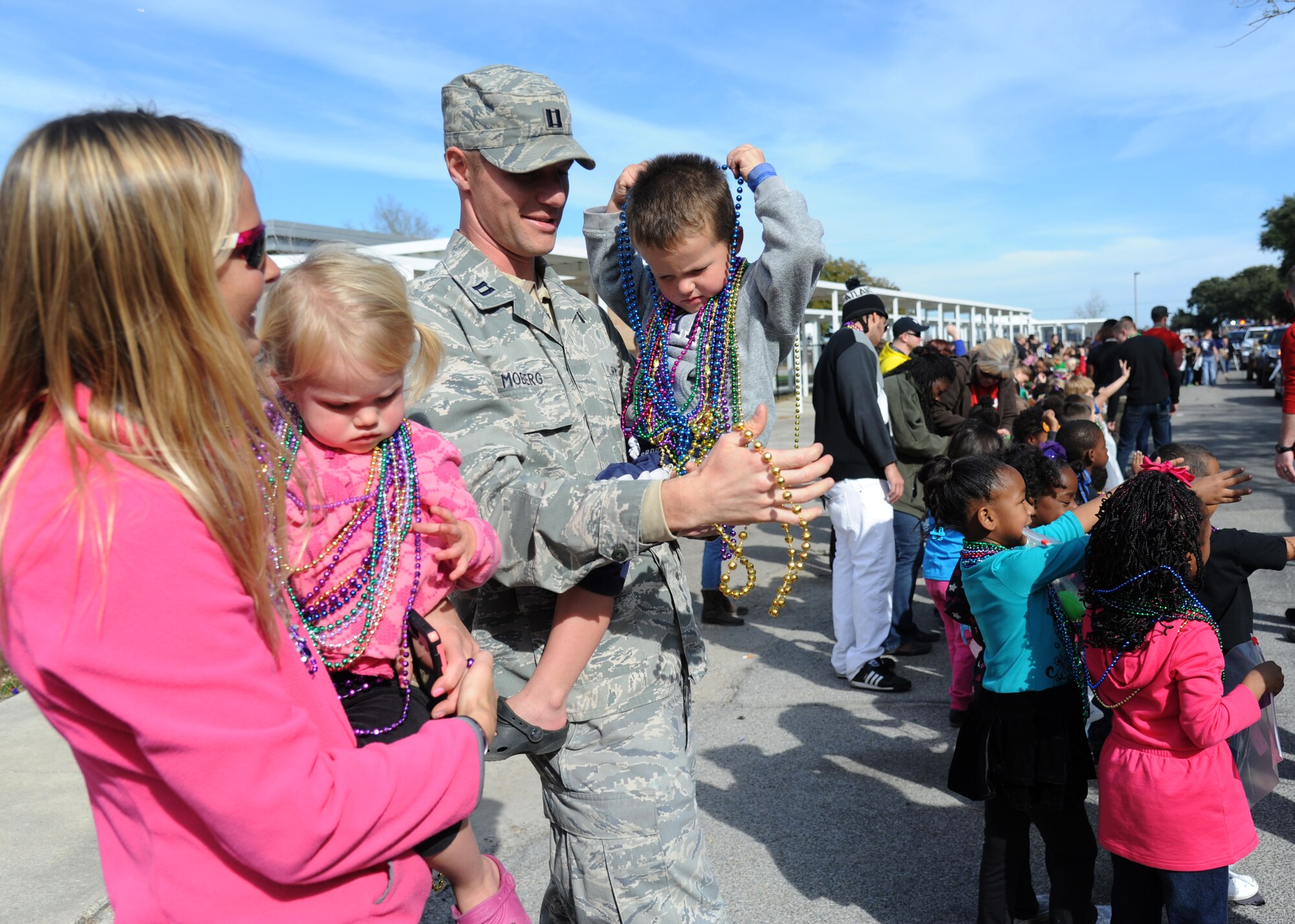Capt. Matthew Moberg, 81st Dental Squadron dentist, his wife, Camille, and children, Selah Mae and Judson, attend the Jeff Davis Elementary School Mardi Gras Parade in Biloxi, Miss., Feb. 13, 2015. Brig. Gen. Patrick Higby, 81st Training Wing commander, and Chief Master Sgt. Harry Hutchinson, 81st TRW command chief, served as Grand Marshalls for the event. (U.S. Air Force photo by Kemberly Groue)