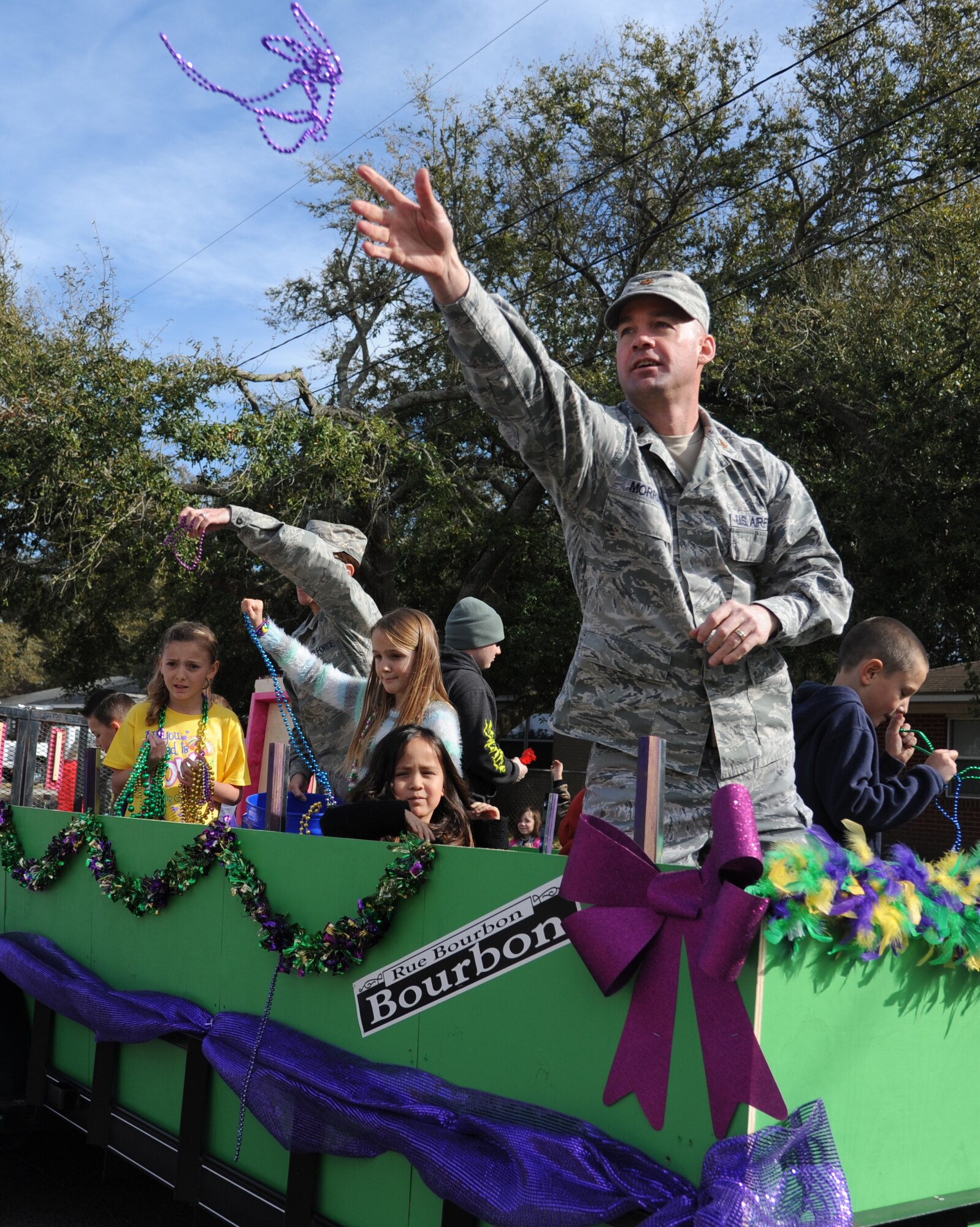 Maj. Edward Morris, 81st Medical Group executive officer, throws beads into the crowd during the Jeff Davis Elementary School Mardi Gras Parade in Biloxi, Miss., Feb. 13, 2015.  The Keesler Honor Guard and base leadership also participated in the festivities.  (U.S. Air Force photo by Kemberly Groue)