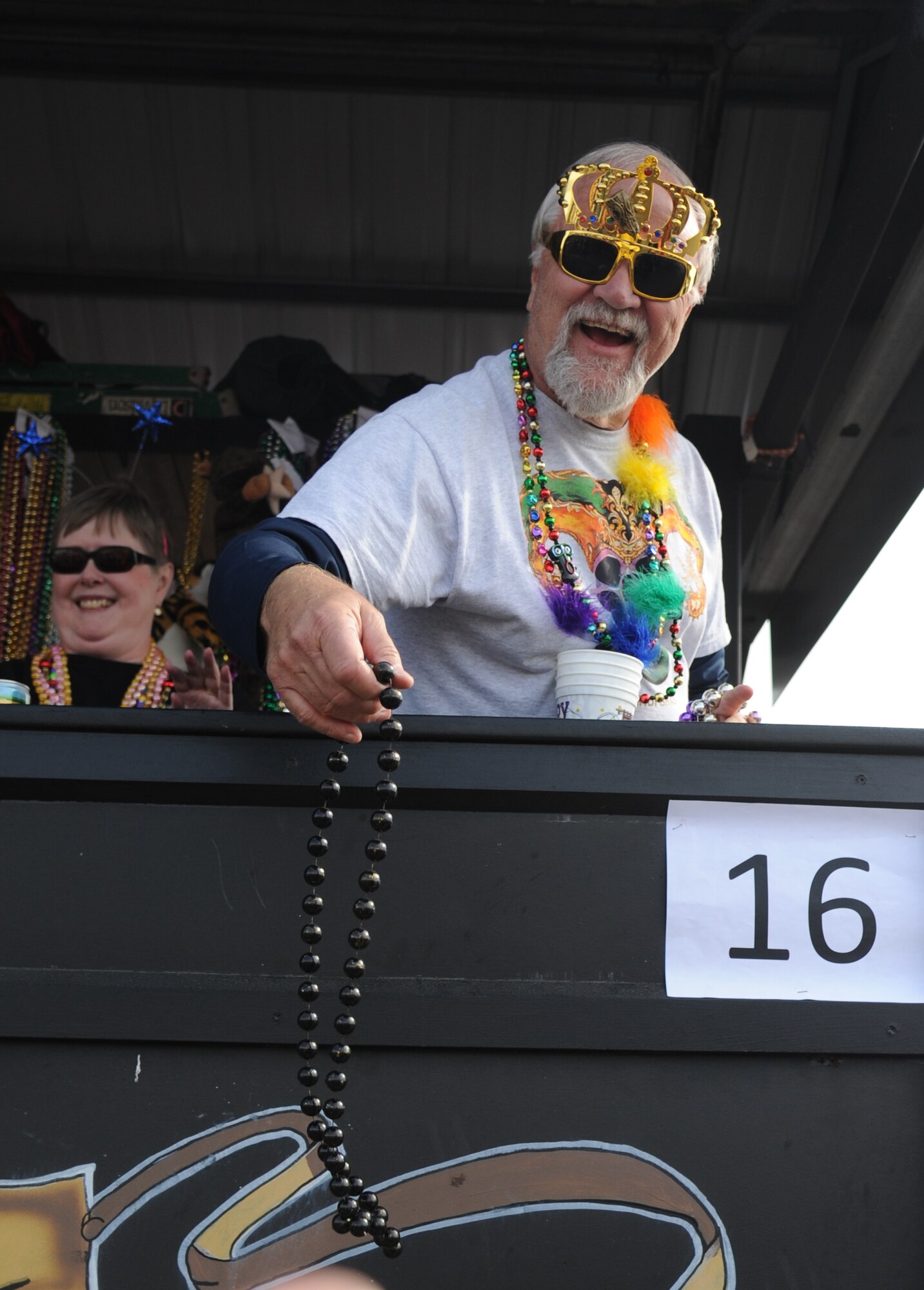 Walter Hack, Jr. throws beads into the crowd during the North Bay Area Mardi Gras Parade in D’Iberville, Miss., Feb. 16, 2015.  Leadership from Keesler Air Force Base, Airmen carrying the 50 state flags and the 81st Training Group drum and bugle corps also participated in the festivities. (U.S. Air Force photo by Kemberly Groue)