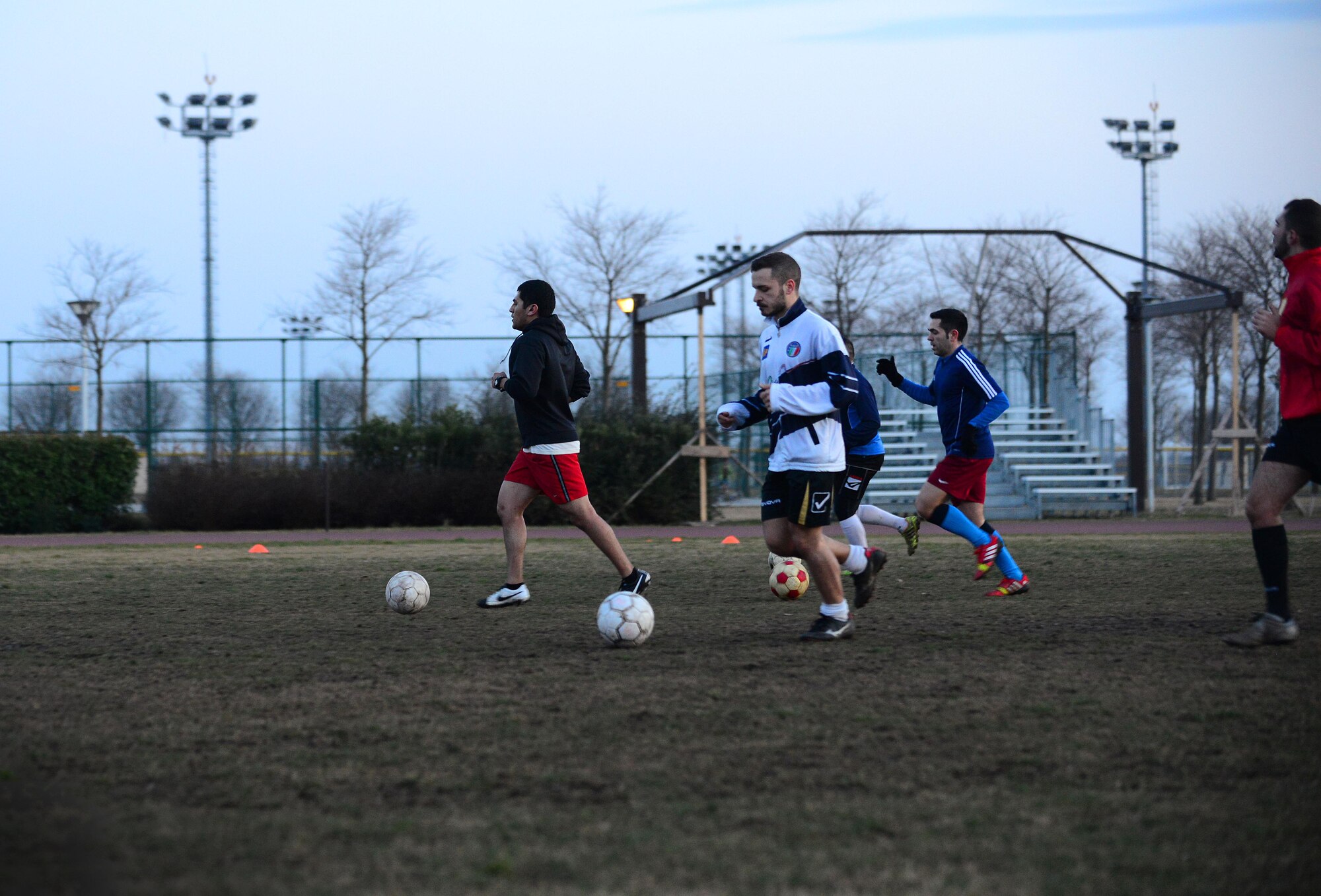 U.S. Air Force Senior Airman Jose Padron-Hernandez, 31st Security Forces Squadron office clerk and operator, dribbles a ball past his teammates during practice, February 16, 2015, at Aviano Air Base, Italy. Padron-Hernandez was asked by the Italian air force security forces members to join the local soccer team after proving his skills during a scrimmage. (U.S. Air Force photo by Senior Airman Matthew Lotz/Released)
