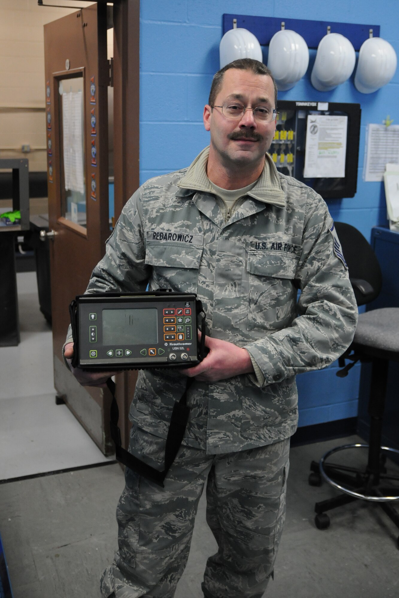 Air Force Reserve Master Sgt. Aldred Redarowicz explains the purpose of a vital piece of Non-Destructive Inspection (NDI) equipment here, Feb. 7, 2015. The ultrasound is used to detect material volume, much like a medical ultrasound machine. Redarowicz is the Non-Commissioned Officer in Charge (NCOIC) of the NDI shop, part of the 910th Aircraft Maintenance Squadron.  U.S. Air Force photo by Tech. Sgt. James Brock