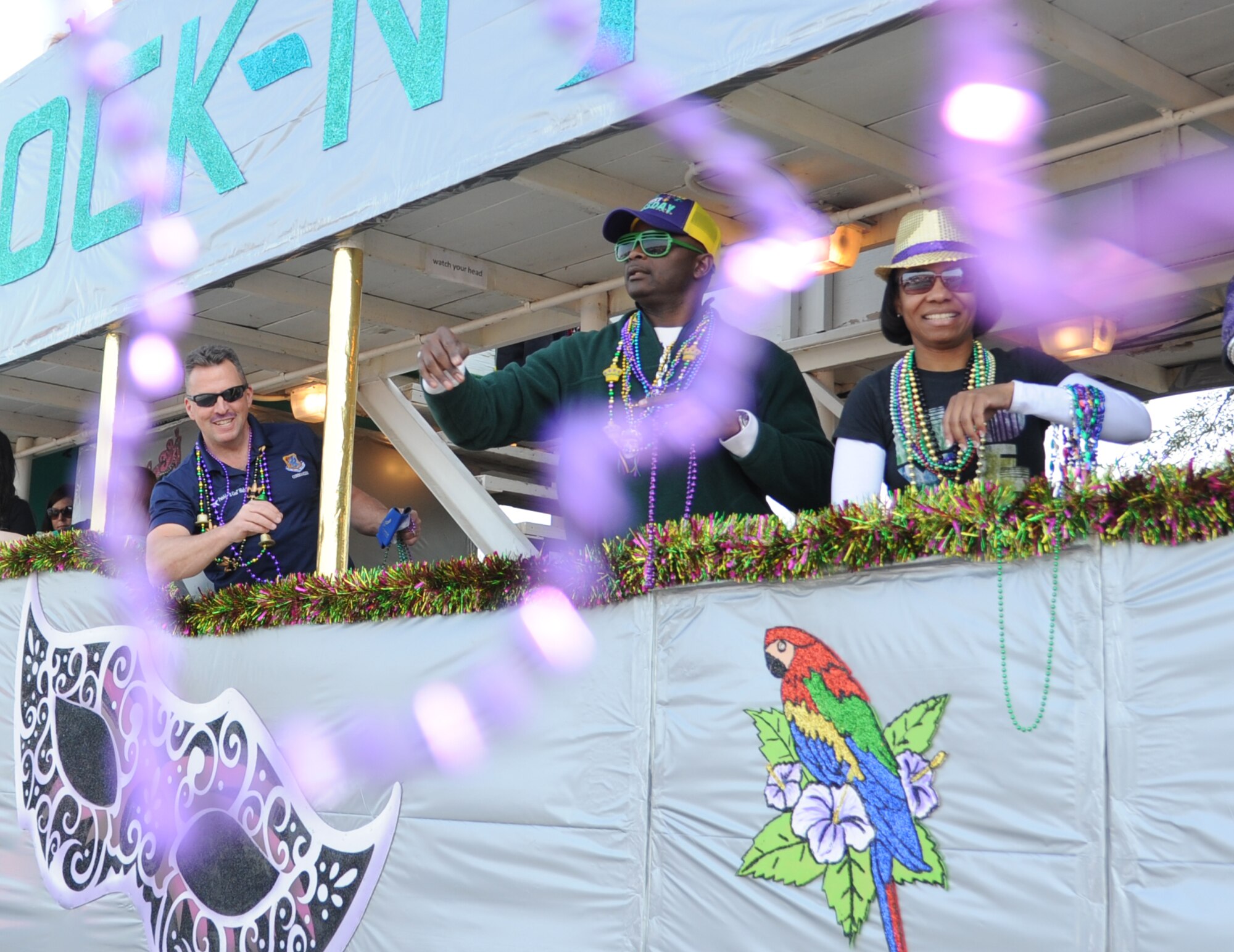 Brig. Gen. Patrick Higby, 81st Training Wing commander, and Chief Master Sgt. Harry Hutchinson, 81st TRW command chief, and Chief Master Sgt. Regina Darnes, 49th Force Support Squadron superintendent, Holloman Air Force Base, N.M., throw beads into the crowd  during the North Bay Area Mardi Gras Parade in D’Iberville, Miss., Feb. 16, 2015.  Airmen carrying the 50 state flags and the 81st Training Group drum and bugle corps also participated in the festivities. (U.S. Air Force photo by Kemberly Groue)