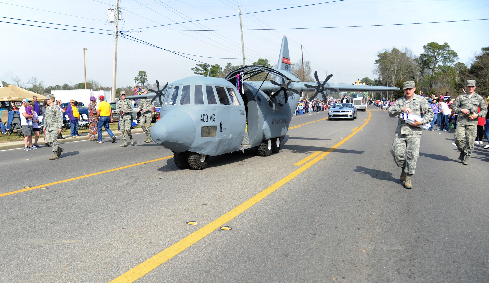 The 403rd Wing’s C-130J model aircraft from Keesler rolls through the crowded streets during the North Bay Area Mardi Gras Parade in D’Iberville, Miss., Feb. 16, 2015.  Leadership from Keesler Air Force Base Airmen carrying the 50 state flags and the 81st Training Group drum and bugle corps also participated in the festivities. (U.S. Air Force photo by Kemberly Groue)