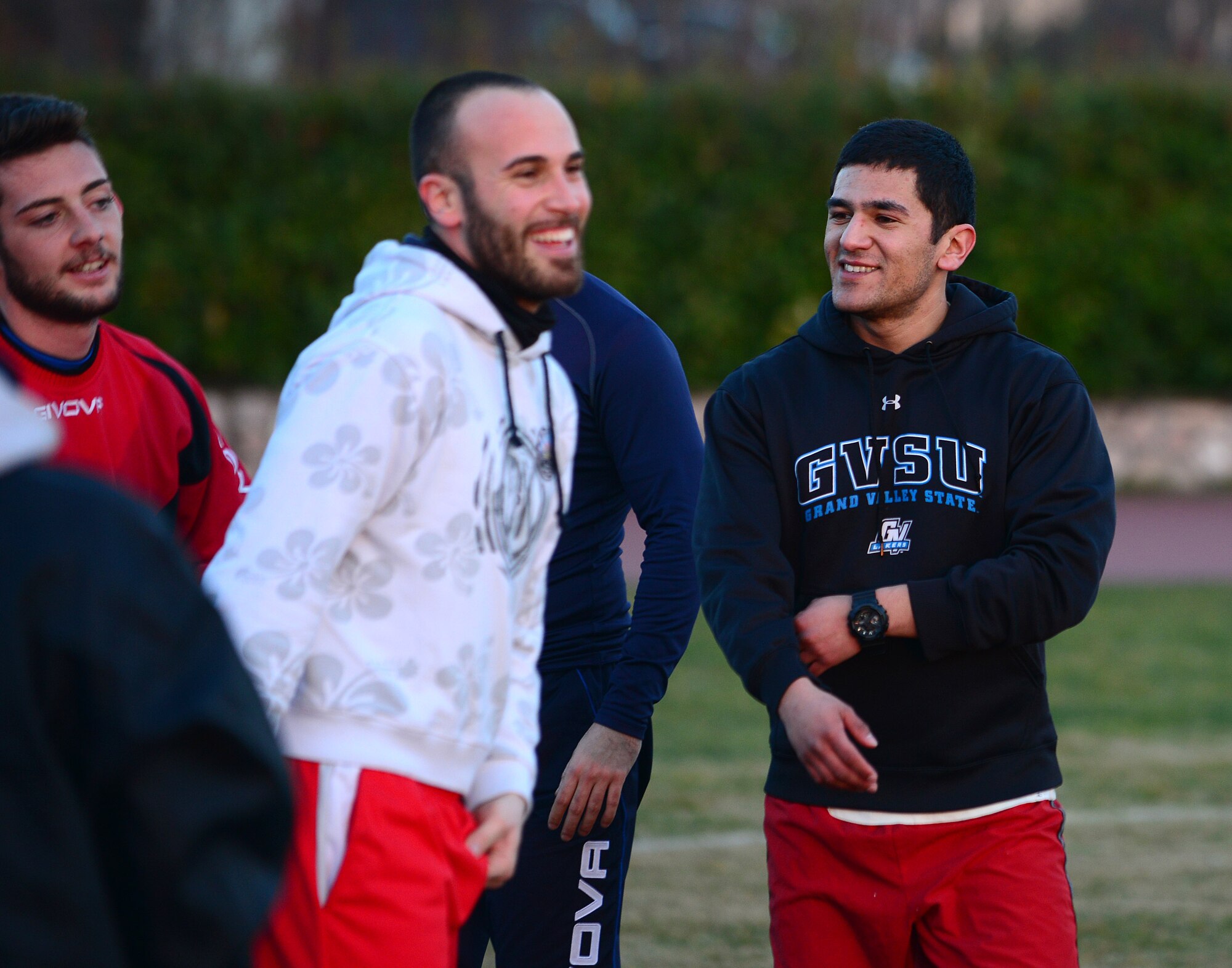 U.S. Air Force Senior Airman Jose Padron-Hernandez, 31st Security Forces Squadron office clerk and operator, jokes with his Italian teammates during practice, February 16, 2015, at Aviano Air Base, Italy. Padron-Hernandez was asked by the Italian air force security forces members to join the local soccer team after proving his skills during a scrimmage. (U.S. Air Force photo by Senior Airman Matthew Lotz/Released)