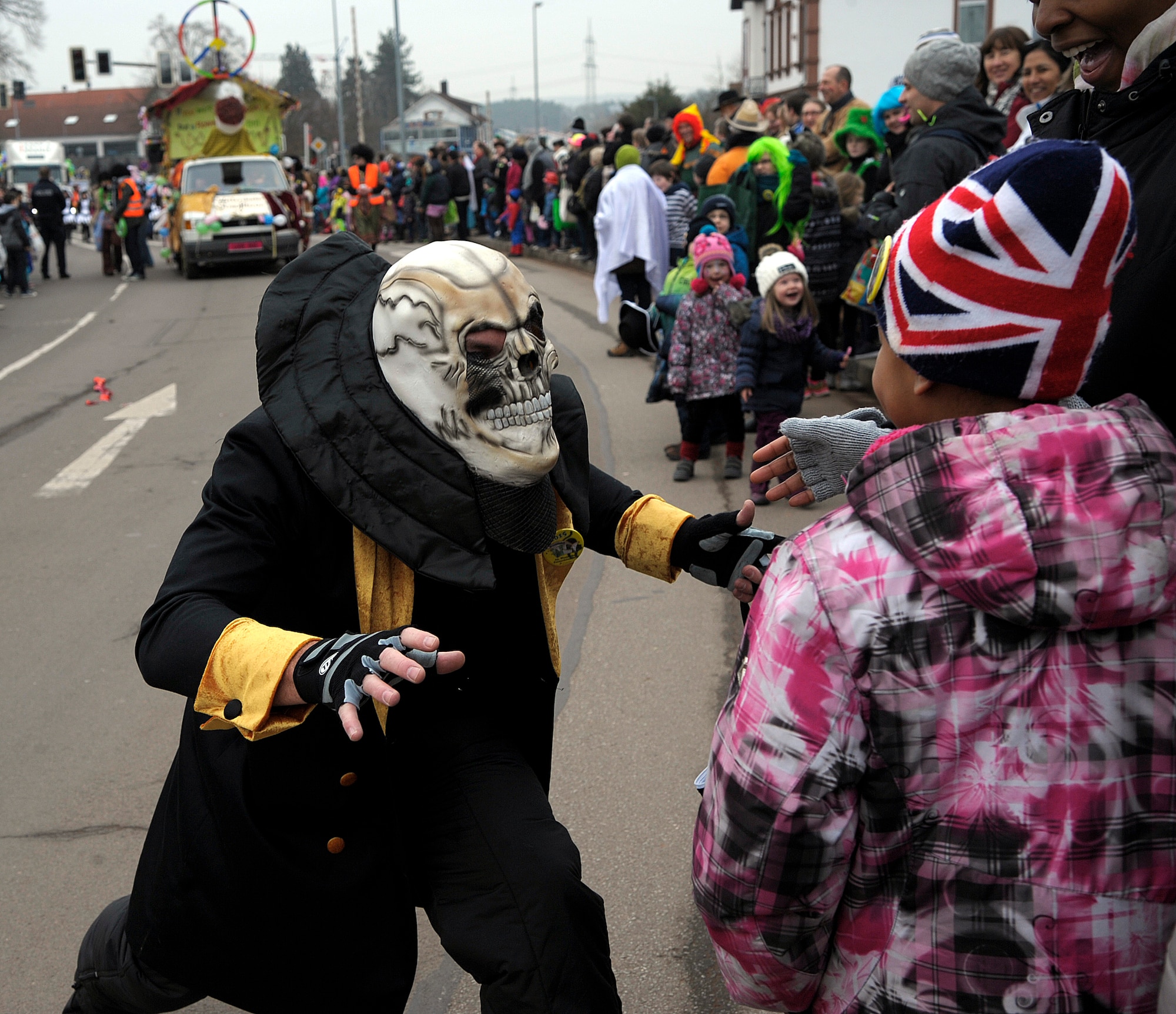 A parade participant interacts with a crowd member during the Fasching parade in Ramstein-Miesenbach, Germany, Feb. 17, 2015. More than 1,400 participants, many of whom were in costume, marched or drove in the parade for more than two hours entertaining the local crowd. (U.S. Air Force photo/Senior Airman Timothy Moore)
