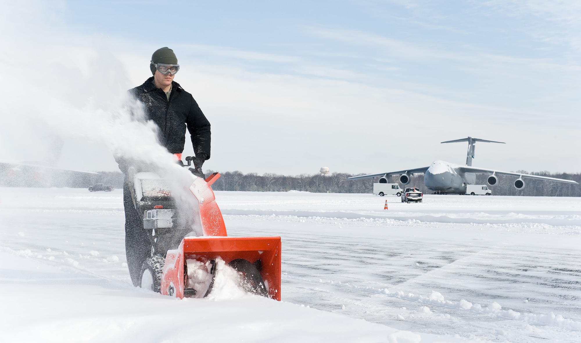 Senior Airman Griffin Toland, from the 436th Maintenance Squadron Aero Repair section, clears snow between two aircraft maintenance hangars Feb. 17, 2015, on Dover Air Force Base, Del. Toland was one of many Team Dover members tasked to clear snow, keeping the base operational during and after the snow storm. (U.S. Air Force photo/Roland Balik)