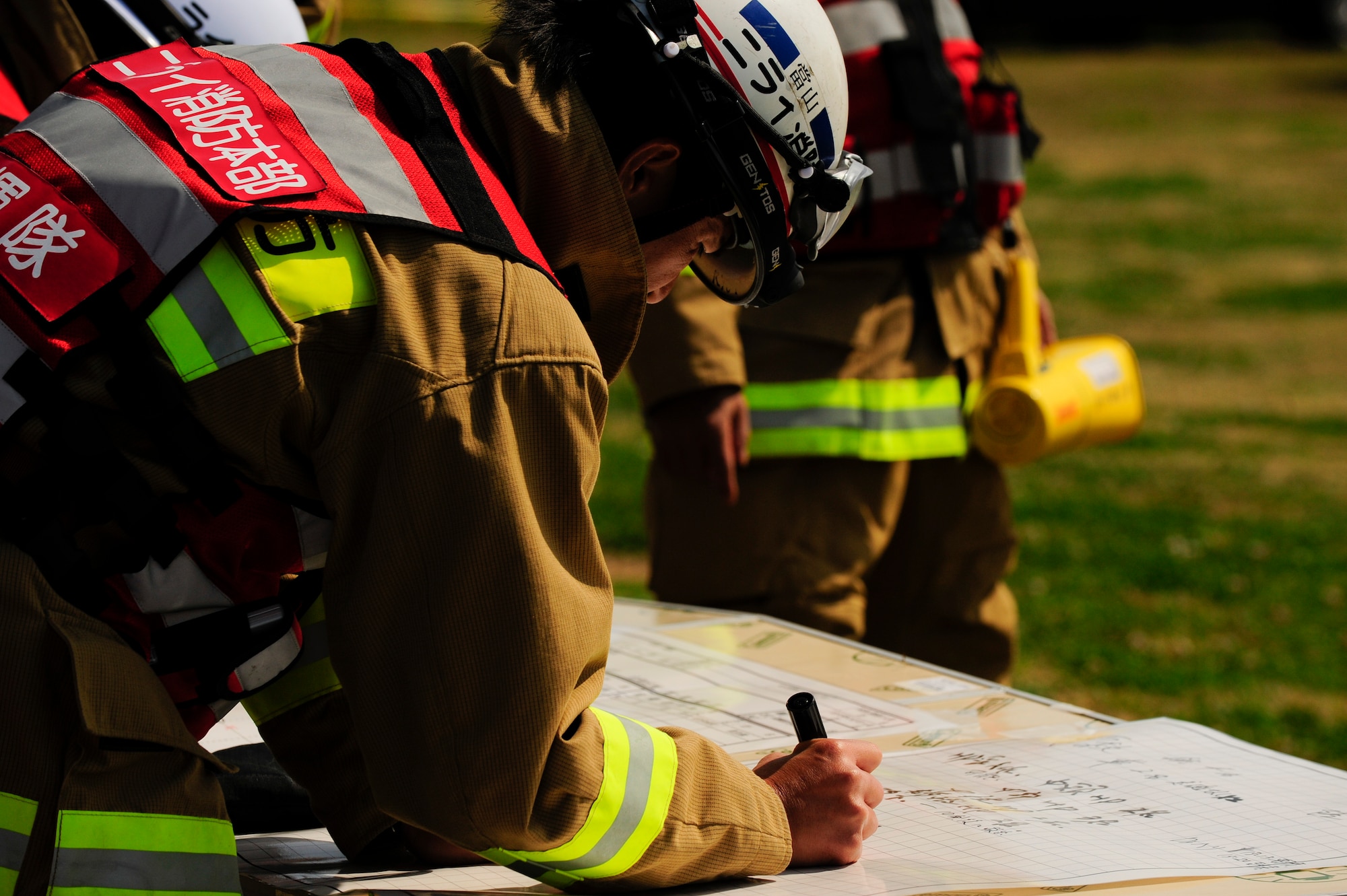A Nirai Fire Department firefighter annotates emergency plans during a bilateral training exercise on Torii Station, Japan, Feb. 17, 2015. The exercise simulated an aircraft mishap and involved the participation of U.S. Military and Japanese response agencies. Their readiness and interoperability were tested as they worked together to provide care to those with simulated injuries.   (U.S. Air Force photo by Airman 1st Class John Linzmeier)