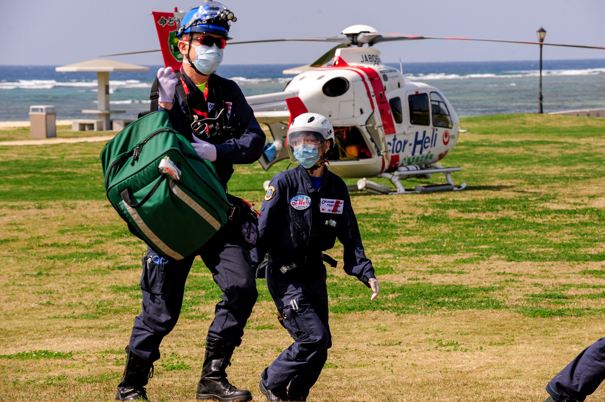Terutake Yonemori, Urasoe General Hospital flight doctor, and Ayumi Kinjo, UGH flight nurse, approach a mock aircraft mishap emergency on Torii Station, Japan, Feb. 17, 2015. They joined other emergency response teams from various departments of the Okinawa Prefecture and Kadena Air Base as part of an annual bilateral aircraft mishap exercise. (U.S. Air Force photo by Airman 1st Class John Linzmeier)