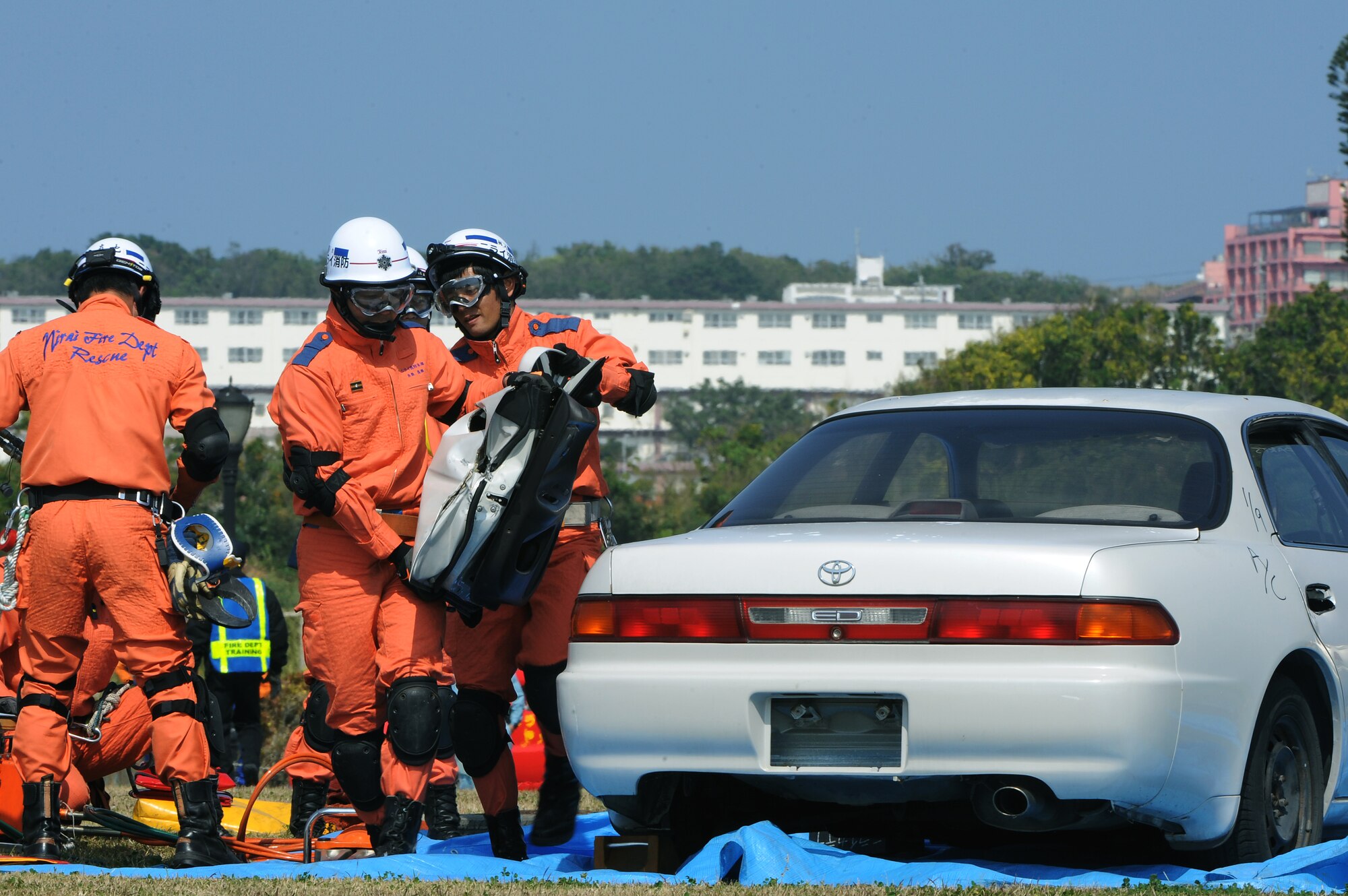 First responders from Nirai Fire Department remove the door from a privately owned vehicle in order to extract and provide care to a simulated victim during a bilateral training exercise on Torii Station, Japan, Feb. 17, 2015. During the exercise, the readiness and interoperability of U.S. military and Japanese emergency response agencies was tested as medical personnel responded to simulated injuries, firefighters doused contained fires and members of the 33rd Rescue Squadron performed a simulated rescue operation. (U.S. Air Force photo by Airman 1st Class Zade C. Vadnais)