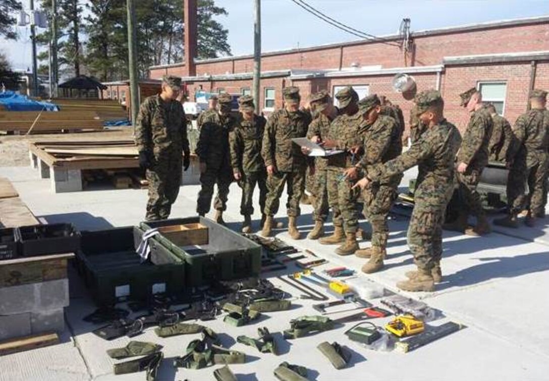 Marines in Basic Combat Engineer Class 10-15 look over an SL3 inventory sheet to a Carpenter's Kit.