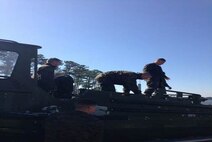 Marines of BCE 13-15 load a Bridge Erection Boat on its trailer.
