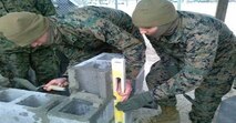 Marines of BCE 14-15 make sure concrete block is plumb.
