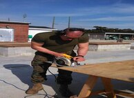 Marine in BCE 15-15 makes a precision cut to a sheet of plywood.