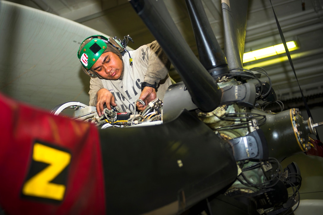 U.S. Navy Petty Officer 1st Class Adrian Casas conducts maintenance on an engine of an E-2C Hawkeye aircraft in the hangar bay of the aircraft carrier USS Carl Vinson in the U.S. 5th Fleet area of operations, Feb. 9, 2015. Casas is an aviation machinist’s mate assigned to the Carrier Airborne Early Warning Squadron 116.