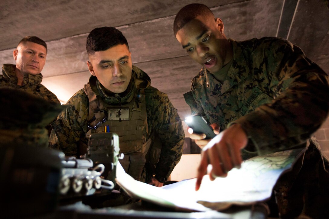 Marine Corps Staff Sgt. Rogelio Villanueva, from left, Marine Corps 1st Lt. Michael Alvarado and Marine Corps Capt. Justin T. Gaines plot coordinates on a map during field training exercise No Easy Day on Camp Lejeune, N.C., Feb. 2, 2015. Villanueva is an operations chief, Alvarado is a platoon commander, and Gaines is an executive officer assigned to Bravo Battery, 2nd Low Altitude Air Defense Battalion. The exercise was conducted to test and increase the Marines efficiency and ability to engage an enemy aircraft.