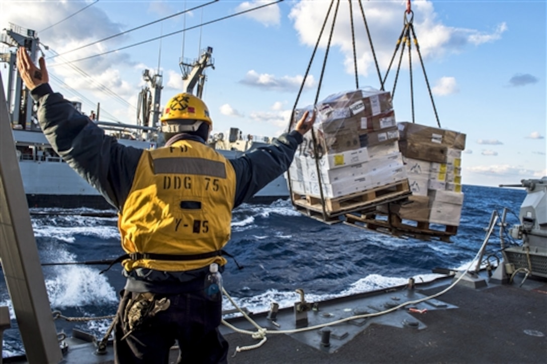 U.S. Navy Petty Officer 2nd Class Joshua Port directs pallet transfers during a replenishment between the guided-missile destroyer USS Donald Cook and the Military Sealift Command fleet replenishment oiler USNS John Lenthall in the Mediterranean Sea, Feb. 12, 2015. The Cook is operating in the U.S. 6th Fleet area of responsibility.