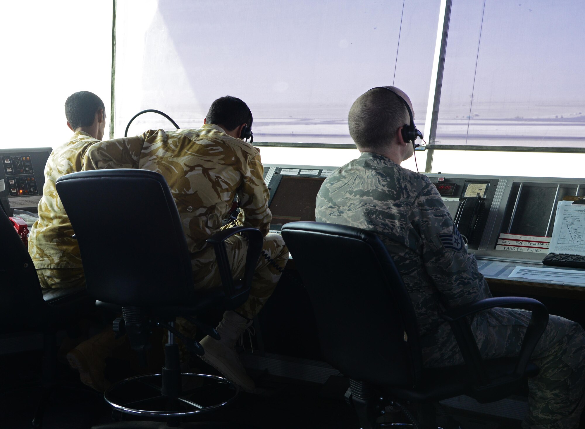 U.S. Air Force and Qatar Emiri Air Force air traffic controllers look out over the airfield, Feb. 17, 2015, at Al Udeid Air Base, Qatar. Airmen assigned to the 379th Expeditionary Operations Support Squadron and Qatari counterparts  work together from the highest vantage point on base –the air traffic control tower— to ensure decisive airpower is generated unobstructed from air traffic congestion.(U.S. Air Force photo by Senior Airman Kia Atkins)