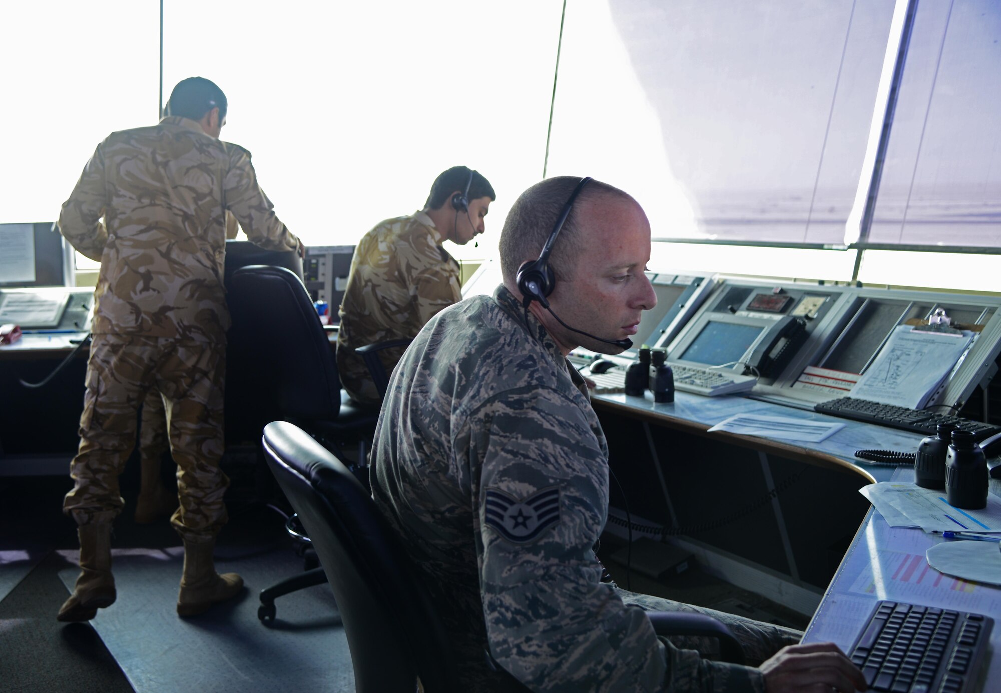 U.S. Air Force and Qatar Emiri Air Force air traffic controllers maintain surveillance of the airfield  from the air traffic control tower, Feb. 17, 2015, at Al Udeid Air Base, Qatar. U.S. and Qatari air traffic controllers provide 24-hour operations directing aircraft in flight and on the flightline at the busiest airfield in the U.S. Air Forces Central Command's area of responsibility. (U.S. Air Force photo by Senior Airman Kia Atkins)