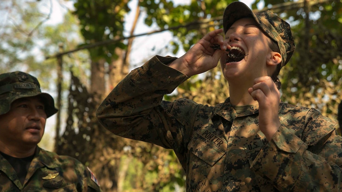 Cpl. Kyleigh M. Porter, from Montross, Va., eats a scorpion Feb. 8 in Ban Chan Krem, Thailand, during exercise Cobra Gold 2015. The Royal Thai Marines demonstrated several jungle survival tactics and asked for U.S. Marine volunteers to participate. Porter is a radio operator with Marine Air Support Squadron 2, Marine Air Control Group 18, 1st Marine Aircraft Wing, III Marine Expeditionary Force. (