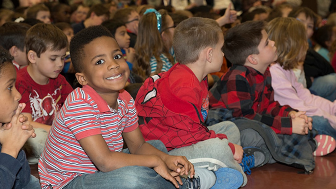 Students at Sheppard Air Force Base Elementary School listen to a special program perfomed for survivors of the battle of Iwo Jima during the 70th Iwo Jima Veteran's Program by the Sheppard Choir at Sheppard Air Force Base, Texas, February 13, 2015. Students sang special songs for the event and sixth grade students read poems they wrote for the occasion.