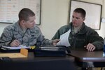 Airman 1st Class Nicholas Sirois and Staff Sgt. Michael Sirois review record documentation while particpating in Sentry Savannah 15-1, Feb. 13, 2015, Savannah, Georgia.  Sentry Savannah 15-1 is the Air National Guard's largest Fighter Integration, Air-to-Air, training exercise encompassing 4th and 5th generation aircraft.