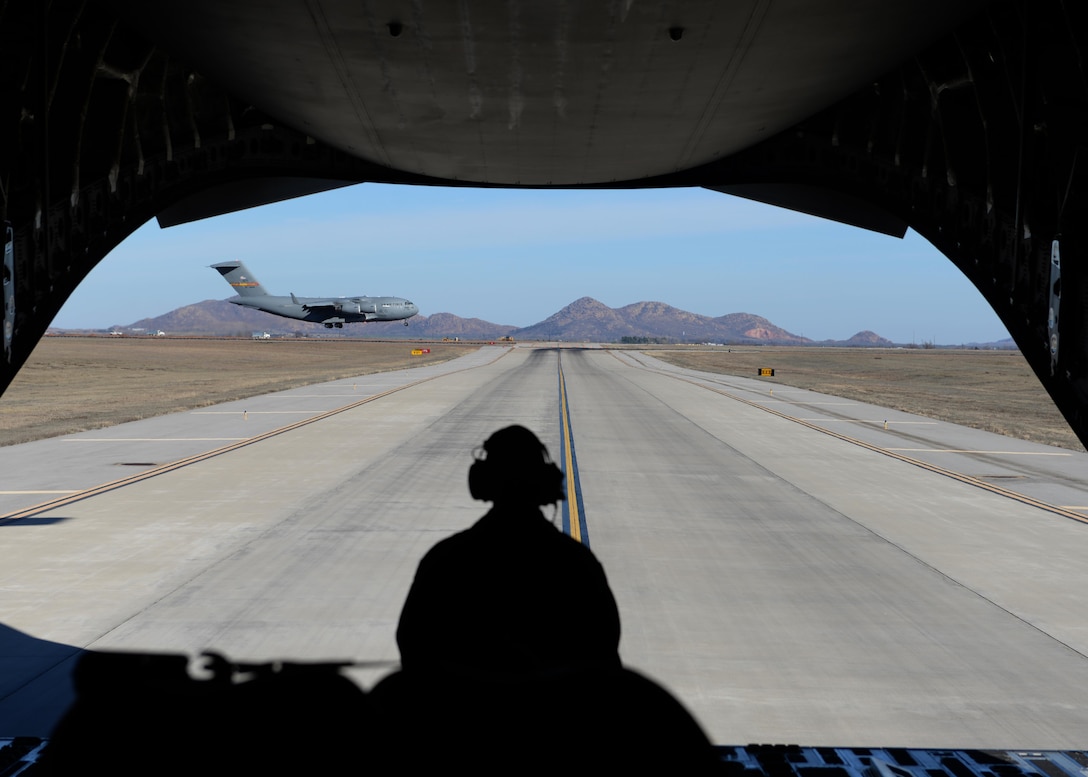 Tech. Sgt. Donnie McCorkle watches a C-17Globemaster III land, Feb. 12, 2015, at Altus Air Force Base, Okla. McCorkle is a C-17 loadmaster and was preparing for a combat off-load, where cargo is pushed out of the cargo door while the aircraft is taxiing. This demonstration was a part of a familiarization flight to help air traffic controllers understand what aircrews do and how important it is to maintain communication between the aircraft and control tower. (U.S. Air Force photo/Airman 1st Class Nathan Clark)