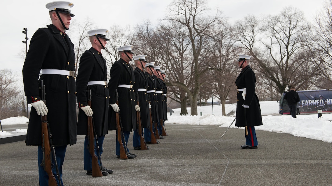 Marines stand poised to preform drill movements during the Iwo Jima Wreath Laying Ceremony at the Marine Corps War Memorial in Arlington, Va. on Feb. 19, 2015. The wreath laying recognized the 70th anniversary of the battle and the veterans' sacrifice.