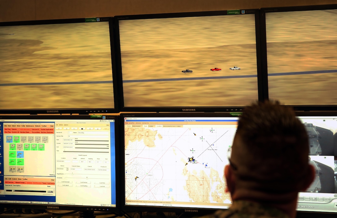 Gunnery Sgt. Hector Viramontes, combat instructor, Headquarters Battalion, observes a combat simulation created by the joint programing of the Combat Convoy Simulator and the Deployable Virtual Training Environment at Camp Wilson, Feb. 11, 2015. Marine Wing Support Squadron 371 was the first unit to experience the combination, which allowed the marines to conduct simulated company sized operations. (Official Marine Corps photo by Lance Cpl. Thomas Mudd/ Released)