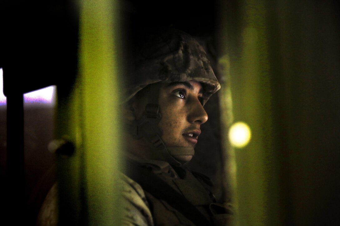 Lance Cpl. Andres Casteneda, security forces, Marine Wing Support Squadron 371, scans the area in front of his vehicle while acting as a long range Quick Reaction Force in the Combat Convoy Simulator at Camp Wilson, Feb. 11, 2015. The Marines of MWSS 371 responded to the simulation, even when the exercise did not go as planned. (Official Marine Corps photo by Lance Cpl. Thomas Mudd/ Released)