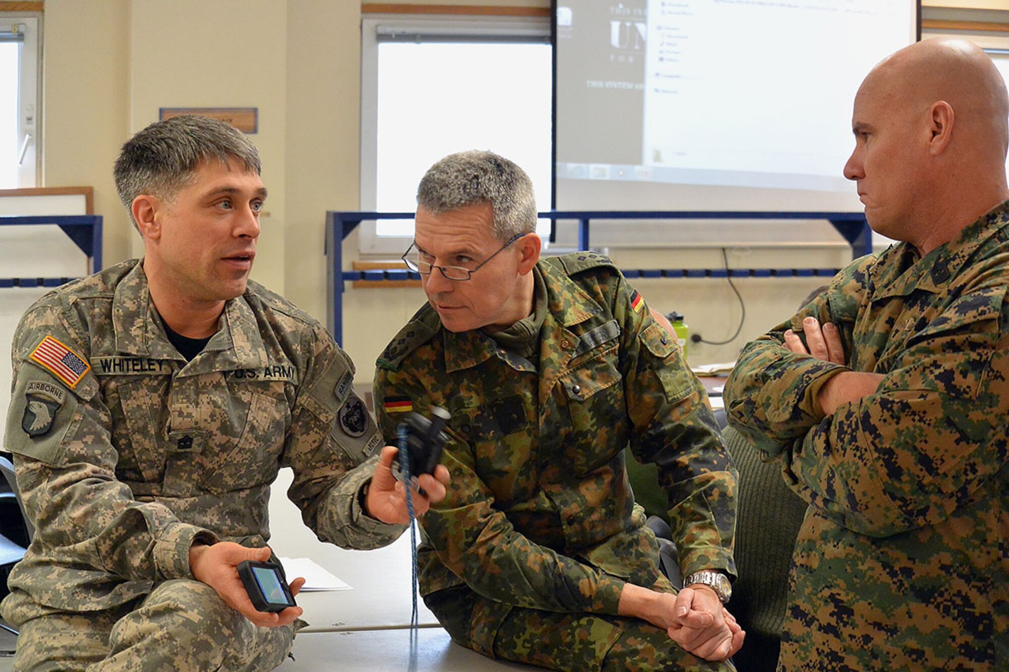 NWTC 1st Sgt. Robert Whiteley discusses his global positioning system with German Col. Michael Varter and U.S. Marine Corps Sgt. Maj. Steven Brunner between presentations at the U.S. Army Alaska-hosted international Cold Region Military Mountaineering Collaborative Event at the Black Rapids Training Site. BRTS was the classroom site Feb. 9 through 12 for participants from 12 nations exchanging ideas about tactics, techniques and procedures for dealing with harsh weather and terrain. (U.S. Army photos/John Pennell)