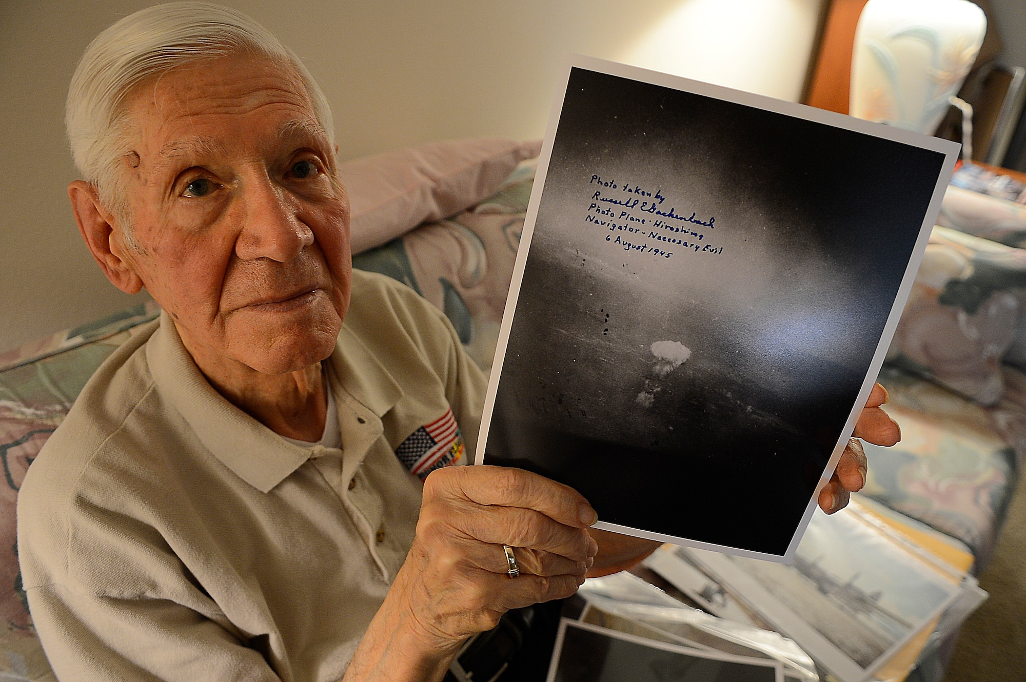 Russell Gackenbach, the navigator aboard the B-29 Superfortress, Necessary Evil, during the nuclear bombing mission over Hiroshima, japan on Aug. 6, 1945, shows a photo he took during the historic day, Clearwater, Fla., Feb 10, 2015.  Gackenbach is the last surviving member from the mission. (U.S. Air Force photo by Tech. Sgt. Brandon Shapiro/Released).