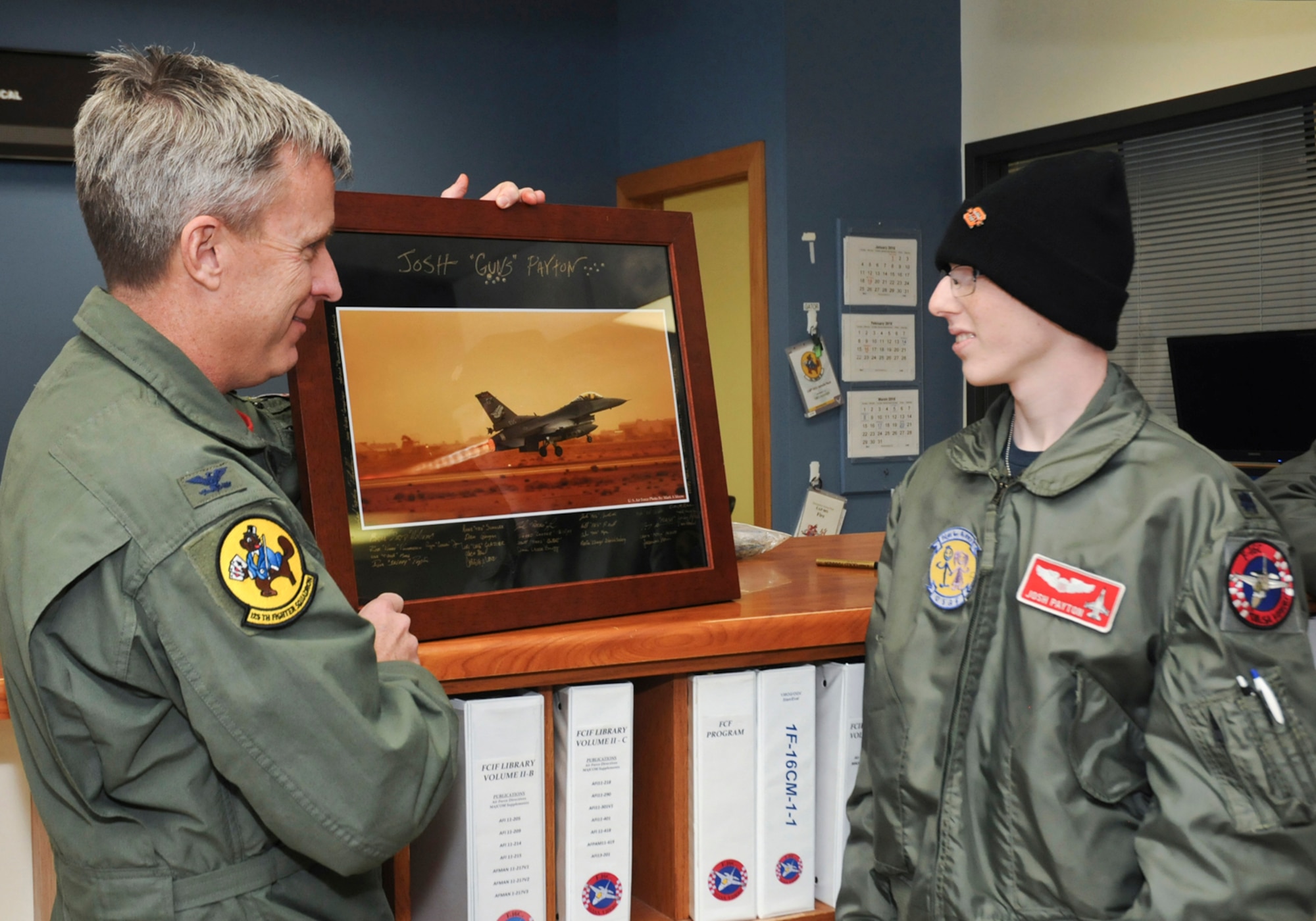 Col. Rick Poplin, 138th Operations Group (OG) Commander presents "pilot for a day" Josh Payton with a token of his appreciation for visiting as an honored guest Feb. 19, 2015, at the Tulsa Air National Guard base, Tulsa, Okla.  The pilot for a day program is intended to recognize and honor children with potentially life threatening illnesses and started at the 138th in May 2012, and has hosted seven children since it began.  (U.S. National Guard photo by Senior Master Sgt.  Preston L. Chasteen/Released)