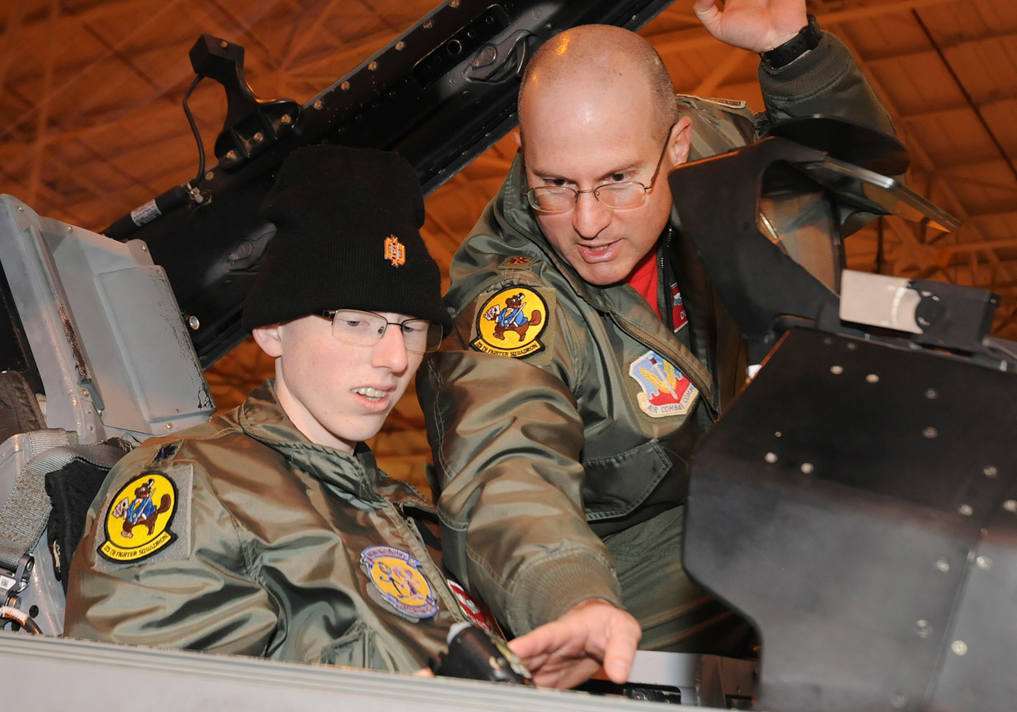 Josh Payton, the 138th Fighter Wing's "pilot for a day" is briefed on the cockpit functionality of an F-16 by Maj. Michael "Deuce" Scorsone Feb. 19, 2015, at the Tulsa Air National Guard base, Tulsa, Okla.  The pilot for a day program is intended to recognize and honor children with potentially life threatening illnesses and started at the 138th in May 2012, and has hosted seven children since it began.  (U.S. National Guard photo by Senior Master Sgt.  Preston L. Chasteen/Released)