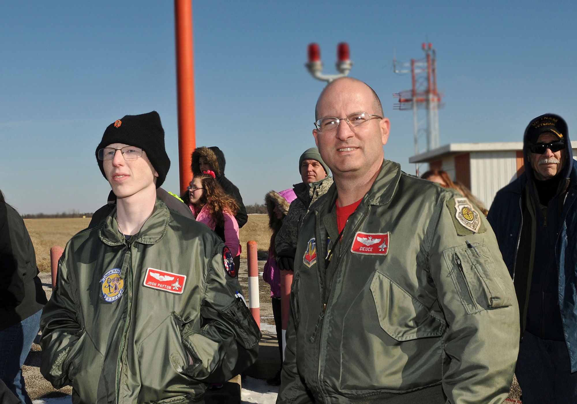 Josh Payton, the 138th Fighter Wing's "pilot for a day" and Maj. Michael "Deuce" Scorsone watch F-16's take off near the runway Feb. 19, 2015, at the Tulsa Air National Guard base, Tulsa, Okla.  The pilot for a day program is intended to recognize and honor children with potentially life threatening illnesses and started at the 138th in May 2012, and has hosted seven children since it began.  (U.S. National Guard photo by Senior Master Sgt.  Preston L. Chasteen/Released)