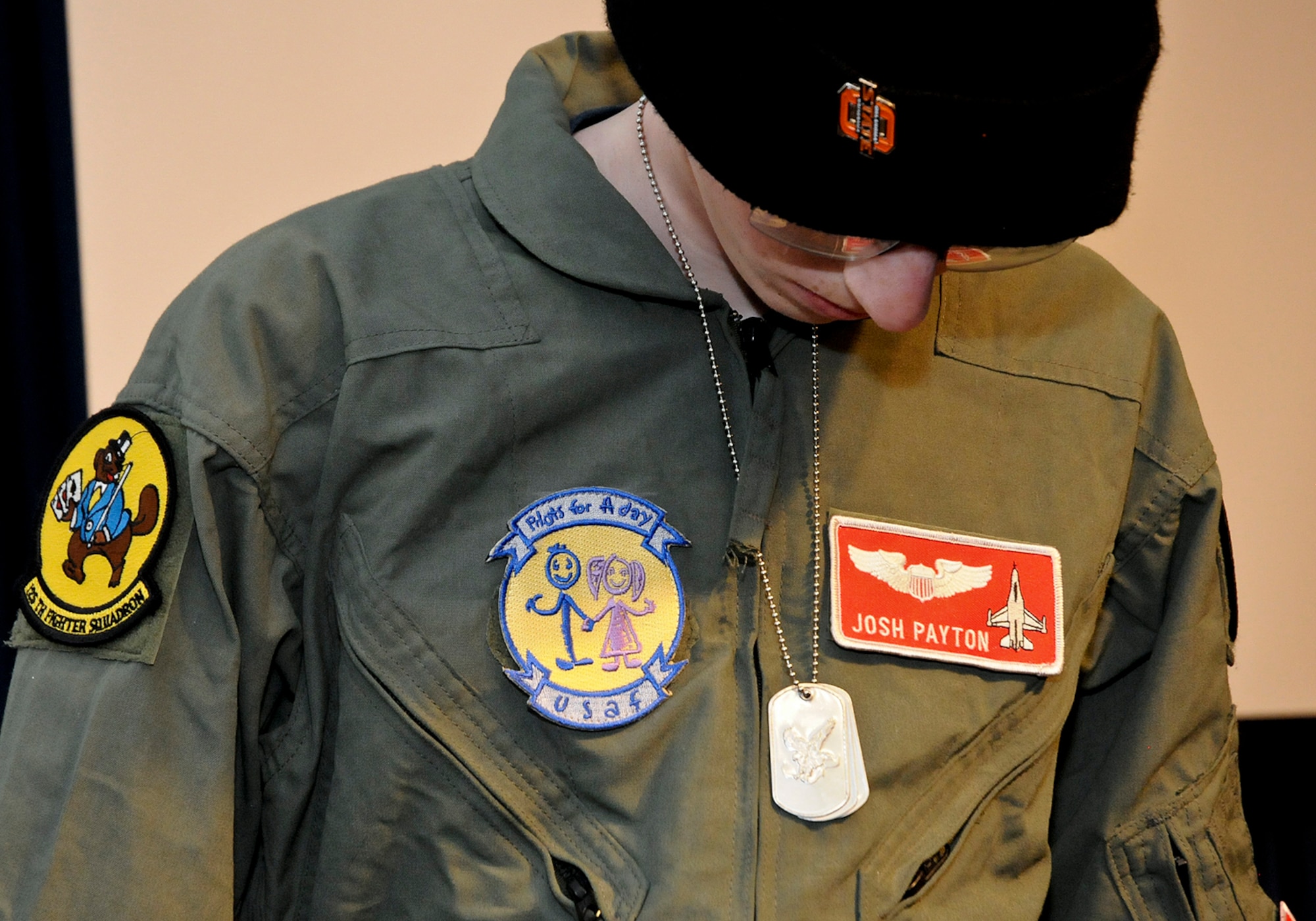 Josh Payton, "pilot for a day" admires his new dog tags while serving as an honored guest of the 138th Fighter Wing Feb. 19, 2015, at the Tulsa Air National Guard base, Tulsa, Okla.  The pilot for a day program is intended to recognize and honor children with potentially life threatening illnesses and started at the 138th in May 2012, and has hosted seven children since it began.  (U.S. National Guard photo by Senior Master Sgt.  Preston L. Chasteen/Released)