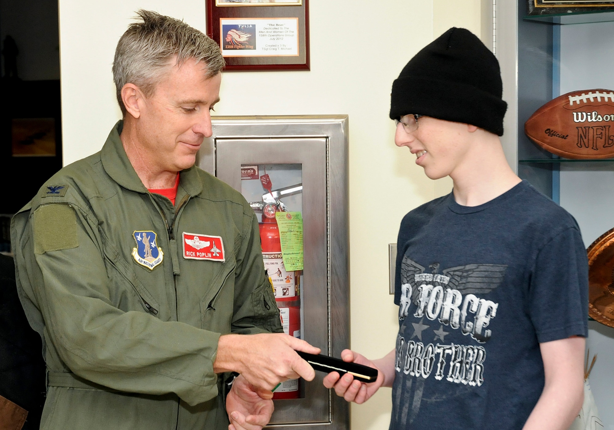 Col. Rick Poplin, 138th Operations Group (OG) Commander presents "pilot for a day" Josh Payton with the keys to the OG during his visit as an honored guest Feb. 19, 2015, at the Tulsa Air National Guard base, Tulsa, Okla.  The pilot for a day program is intended to recognize and honor children with potentially life threatening illnesses and started at the 138th in May 2012, and has hosted seven children since it began.  (U.S. National Guard photo by Senior Master Sgt.  Preston L. Chasteen/Released)