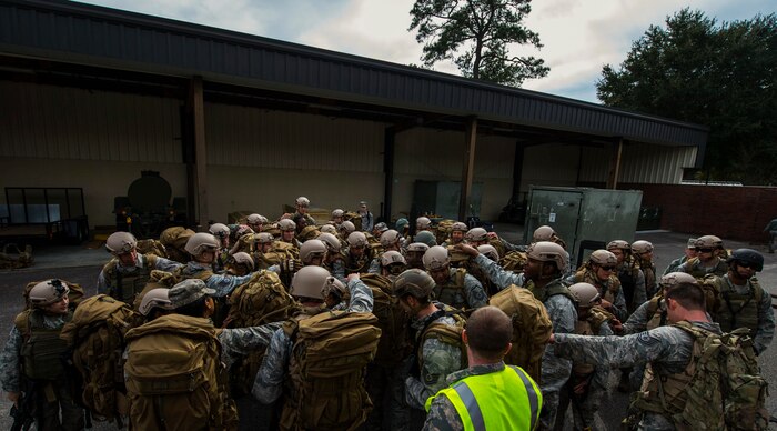 Airmen from the 1st Combat Camera Squadron at Joint Base Charleston, S.C., huddle for the squadron chant Jan. 29, 2015, after completing a 2.2 mile ruck in preparation for their annual validation exercise which evaluates their ability to survive and operate in an austere environment. This ruck was dedicated to former 1 CTCS commander, Col. Aaron Burgstein, who passed away Jan. 27, 2015. Burgstein commanded the squadron from July 2009 to July 2012. (U.S. Air Force photo by Senior Airman Marianique Santos/Released)