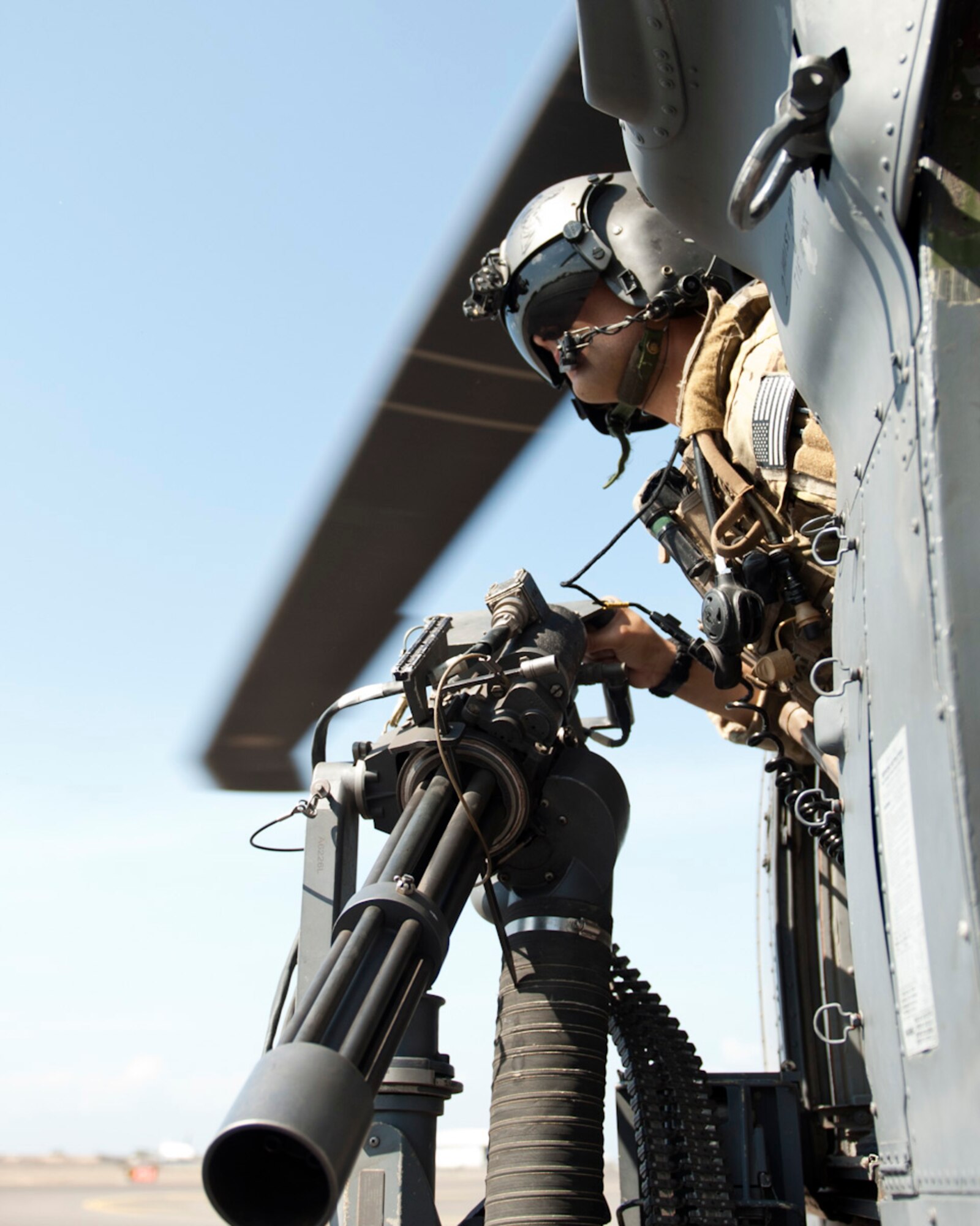 U.S. Air Force Master Sgt. Antonio Jimenez, 303rd Expeditionary Rescue Squadron special mission aviator, glances out of an HH-60 Pave Hawk during a 600-pound weight check at Camp Lemonnier, Djibouti on Jan. 26, 2015. The Weight check was part of the flight inspection to ensure everything is operable prior to a mission. (U.S. Air Force photo by Staff Sgt. Kevin Iinuma) 