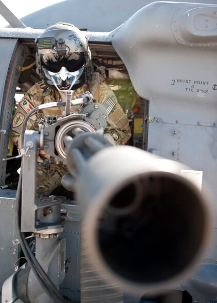 U.S. Air Force Master Sgt. Antonio Jimenez, 303rd Expeditionary Rescue Squadron special mission aviator, simulates ‘stand ready’ with the GAU-2 mini-gun at Camp Lemonnier, Djibouti on Jan. 26, 2015. This position is taken if and when they need to provide combat air support during any rescue mission. (U.S. Air Force photo by Staff Sgt. Kevin Iinuma) 