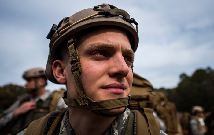 Senior Airman Daniel Johnston, 1st Combat Camera Squadron aerial combat broadcaster, rests on a field at during a 2.2 mile ruck march at Joint Base Charleston, S.C., Jan. 29, 2015. The ruck march was conducted in preparation for their annual validation exercise which evaluates their ability to survive and operate in an austere environment. This ruck was dedicated to former 1 CTCS commander, Col. Aaron Burgstein, who passed away Jan. 27, 2015. Burgstein commanded the squadron from July 2009 to July 2012. (U.S. Air Force photo by Senior Airman Marianique Santos/Released)