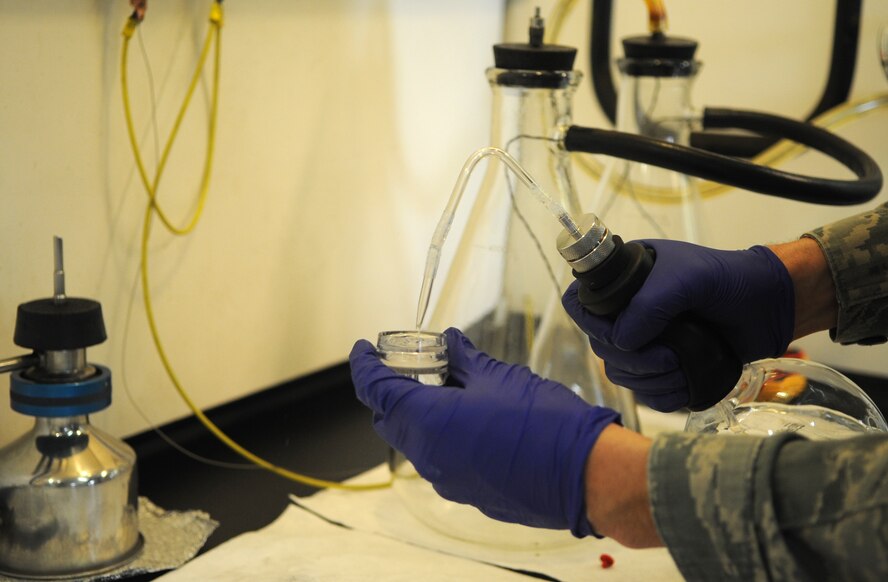 Senior Airman Noah Lazurka, 4th Logistics Readiness Squadron fuels laboratory technician, tests fuel using single weight test pads at Seymour Johnson Air Force Base, North Carolina, Feb. 11, 2014. Aeronautical Engineering Laboratory pads are also used to test for free water in fuel samples. (U.S. Air Force photo/Senior Airman Ashley J. Thum)